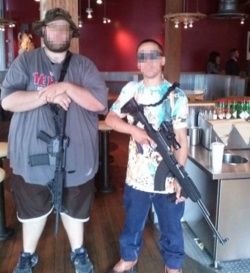 image of two guys out in public with their loaded rifles