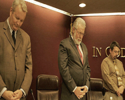 City council members praying before a meeting