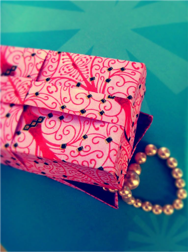 Pink origami gift box filled with vintage pearls