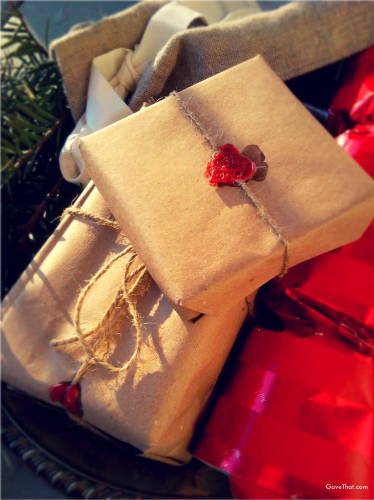 Brown paper wrapped gifts with red wax seals and twine and a Christmas Cracker Bon Bon gift