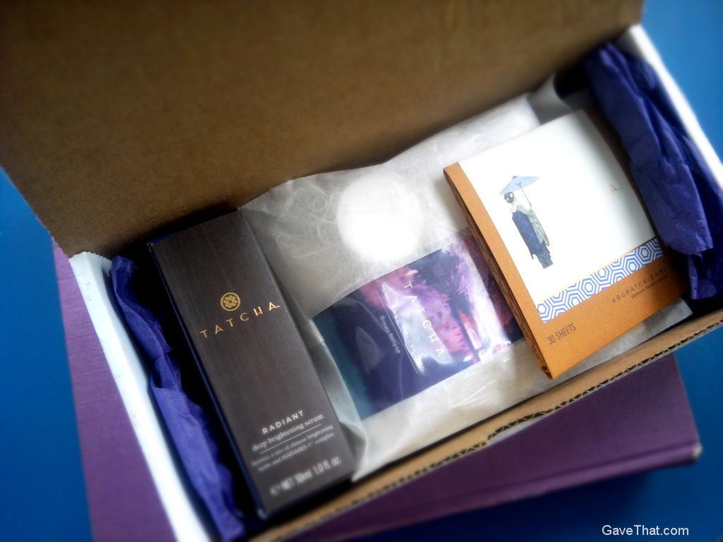 A pretty box of beauty gifts from Tatcha with purple tissue paper and envelopes of cream Mulberry papers