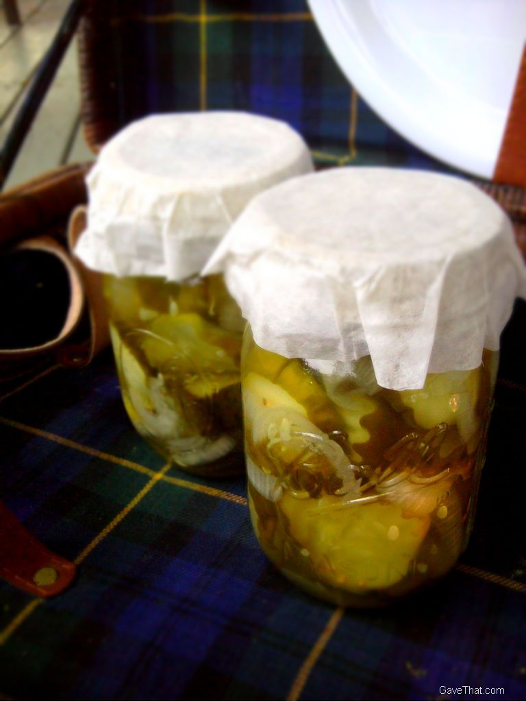 Homemade canning with Bread and Butter pickles in mason jars inside vintage picnic basket ready to give