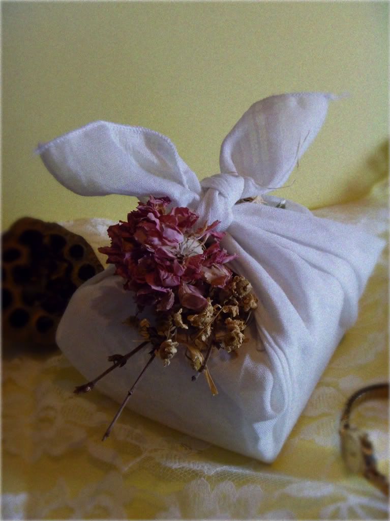 white handkerchief furoshiki wrapped present with dried flowers
